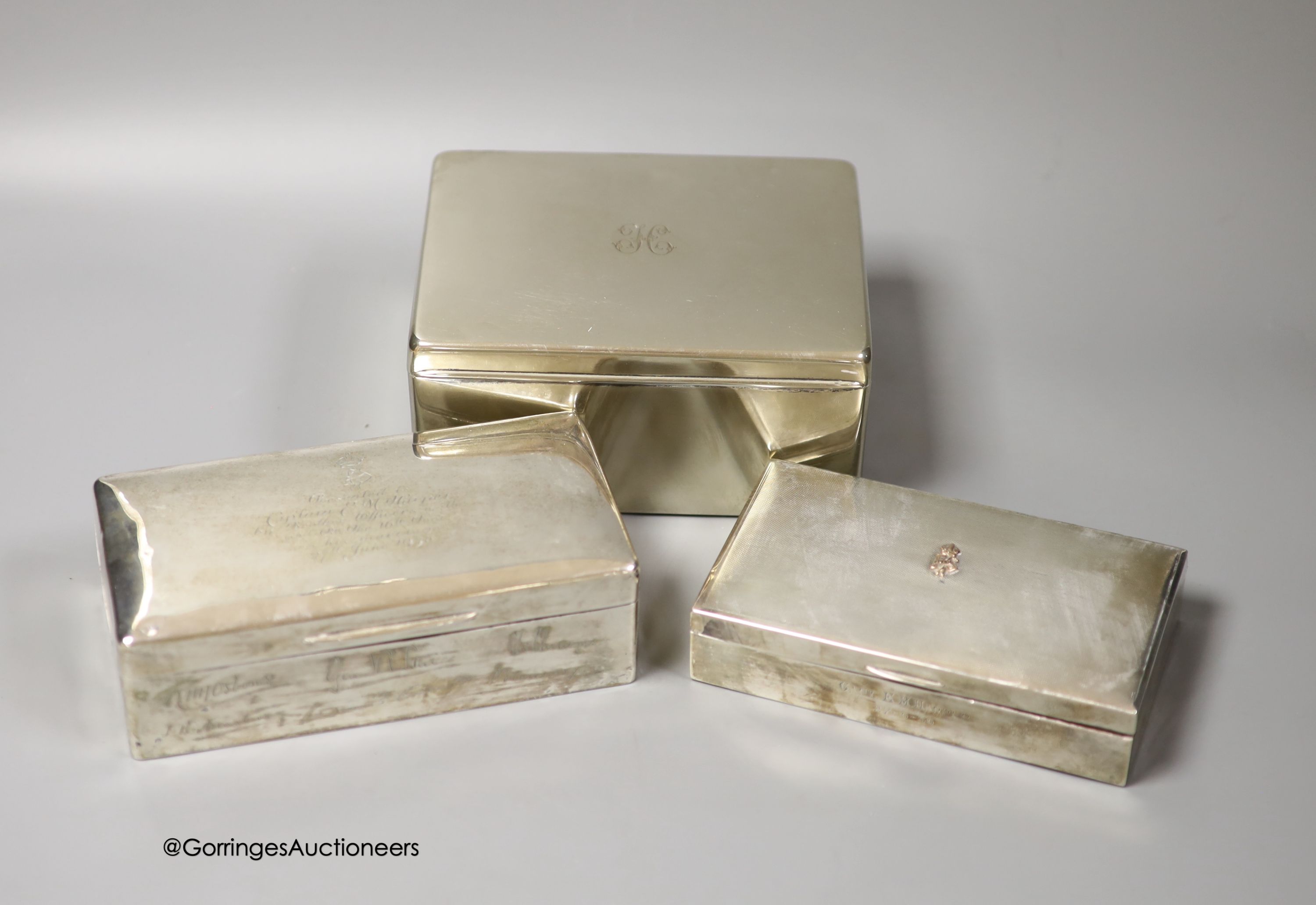 Three 20th century silver mounted cigarette boxes, two with engraved signatures, largest 16.2cm.